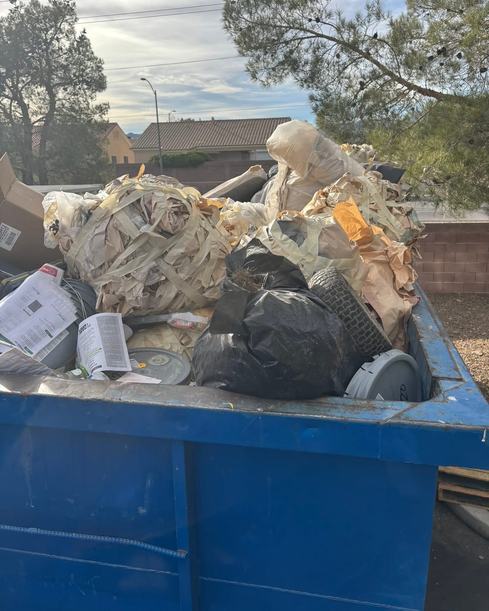 Container full of bagged waste and packaging before compaction.
